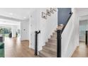 Bright entryway with hardwood floors, staircase with wooden handrail, and neutral paint at 18017 Ramble On Way, Land O Lakes, FL 34638