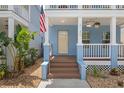 Inviting front porch features a ceiling fan, wood flooring, and views of lush greenery at 2130 W Spruce St, Tampa, FL 33607