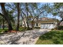 Lovely two-story home featuring a well-manicured lawn, lovely landscaping and a two-car garage at 2175 Oak Forest Ln, Palm Harbor, FL 34683