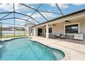 Inviting screened-in pool area with comfortable patio furniture and outdoor grill at 21834 Southern Charm Dr, Land O Lakes, FL 34637