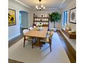 Bright dining room features wood table, neutral chairs, stylish chandelier, and unique decorative shelving at 2400 13Th S Ave, St Petersburg, FL 33712