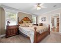 Comfortable main bedroom with a large carved wood bed, ceiling fan, and natural light from windows at 2715 9Th N Ave, St Petersburg, FL 33713