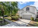 Charming two-story home featuring a two-car garage, arched windows, and mature landscaping at 27330 Coral Springs Dr, Wesley Chapel, FL 33544