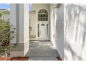 Inviting front entrance with white door, sidelights, and decorative arch window for natural light at 27330 Coral Springs Dr, Wesley Chapel, FL 33544