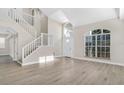 Bright, airy living room with vaulted ceiling, large windows, and open staircase at 27330 Coral Springs Dr, Wesley Chapel, FL 33544