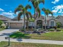 Beautiful single-Gathering home with lush landscaping, mature palms, and a well-maintained lawn under a clear sky at 2908 89Th E Ave, Parrish, FL 34219