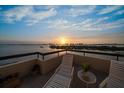 Relaxing balcony featuring comfortable lounge chairs with stunning sunset views overlooking calm waters at 4 Belleview Blvd # 802, Belleair, FL 33756