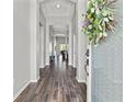 Inviting hallway with wood-look flooring, neutral walls, and an open view to the living spaces at 4214 Canongate Ct, Spring Hill, FL 34609