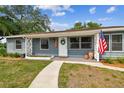 Close up of the front of the home featuring an American Flag and a sidewalk leading to the door at 4403 W Bay Court Ave, Tampa, FL 33611