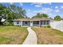 Charming single-story home featuring a well-manicured lawn and inviting walkway leading to a white front door at 4403 W Bay Court Ave, Tampa, FL 33611