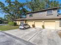 Two-story townhouse with brick and wood facade, showcasing a two-car garage and driveway at 533 E Curlew Pl # 533, Tarpon Springs, FL 34689