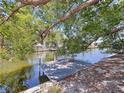 Dock on the water under shady trees offering scenic views and direct access for boating and water activities at 5806 Liverpool Dr, Tampa, FL 33615