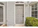 Close-up of the front door, showcasing its classic design and hardware, with a small porch and nearby landscaping at 8101 Interbay Blvd # A, Tampa, FL 33616