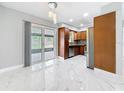 Dining room with marble floors and access to outdoor patio and modern kitchen at 8240 Quail Rd, Seminole, FL 33777