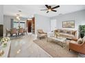 Bright living room featuring elegant marble floors, modern furnishings, and a ceiling fan at 8240 Quail Rd, Seminole, FL 33777