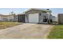 Long concrete driveway leads to a single-car garage, with a stone accent exterior at 8330 Moulton Dr, Port Richey, FL 34668
