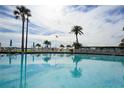 Sparkling community pool with lounge chairs surrounded by lush tropical landscaping at 845 S Gulfview Blvd # 107, Clearwater Beach, FL 33767