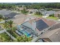 Screened-in pool, lush landscaping, and solar panels seen from an aerial view at 8915 Hannigan Ct, Tampa, FL 33626