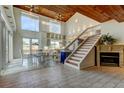 Bright living room featuring high ceilings, wood beams, fireplace, and staircase to the second floor at 919 Sandpiper S Way, St Petersburg, FL 33707