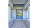 Close-up of the entryway featuring a stylish glass door and neutral-toned pillars at 11240 Marvelwood, Brooksville, FL 34614