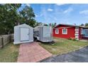 An exterior view of the property, featuring a trailer, a storage unit, and part of the red building at 126 Ridgewood Ave, Brandon, FL 33510
