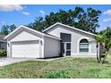Well-maintained home with an attached two-car garage and mature landscaping at 13613 Laraway Dr, Riverview, FL 33579