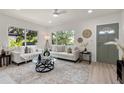 A modern living room featuring stylish seating, a glass coffee table, and views of the outdoor scenery through large windows at 1443 Paloma Ln, Dunedin, FL 34698