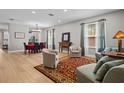 Open living room with hardwood floors, a large rug, neutral paint and a view to the dining area at 19101 Marisa Ridge Pl, Tampa, FL 33647