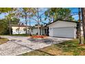 Single Gathering home showcasing a paver driveway leading to an attached 2-car garage at 2001 Pinellas Point S Dr, St Petersburg, FL 33712