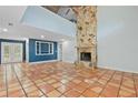 Bright living room featuring terracotta tile flooring, a stone fireplace, and blue accent wall at 2493 6Th Sw Ave, Largo, FL 33770