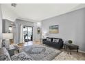 Cozy living room with gray walls, large rug, and a glimpse of the outdoor pool area at 25330 Conestoga Dr, Land O Lakes, FL 34639