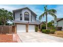 Charming two-story home featuring a two-car garage, landscaped yard, and beautiful architectural details at 3177 Montrose Pl, Palm Harbor, FL 34684