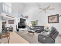 Spacious living room featuring high ceilings, a ceiling fan, plush seating, and a lofted area at 3177 Montrose Pl, Palm Harbor, FL 34684