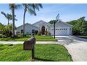 Inviting home exterior featuring a manicured lawn, palm trees, and a basketball hoop at 3238 Cullendale Dr, Tampa, FL 33618