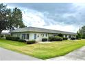 Back of the home featuring a well-manicured lawn and landscaping at 3411 Teeside Dr, New Port Richey, FL 34655