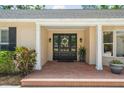 Inviting entryway with a stylish front door, brick patio, and attractive landscaping at 3906 Floyd Rd, Tampa, FL 33618
