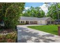 Well-maintained home with mature landscaping, a spacious driveway, and an inviting front entrance at 3906 Floyd Rd, Tampa, FL 33618