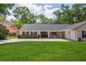 Charming single-story home with a manicured front lawn, classic shutters, and a welcoming front porch at 3906 Floyd Rd, Tampa, FL 33618