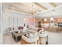 Open-concept living room and kitchen featuring modern decor, hardwood floors, and a large kitchen island at 3923 Corsica Pl, Wesley Chapel, FL 33543