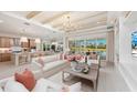 Bright and spacious living room featuring white furniture, hardwood floors, and direct access to the outdoor living space at 3923 Corsica Pl, Wesley Chapel, FL 33543
