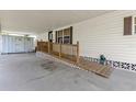 Covered carport and ramp with wooden railing for accessible entry into the home at 4314 12Th Street E Ct, Ellenton, FL 34222
