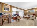 Cozy living room featuring wood paneling, laminate flooring, and ample natural light at 4314 12Th Street E Ct, Ellenton, FL 34222