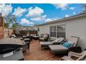 Relaxing outdoor deck with wicker seating, lounge chairs, and a grill for entertaining guests at 5036 Glenhurst Ln, New Port Richey, FL 34653