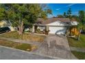 Traditional-style home boasting a two-car garage, brick accents, and a well-manicured front yard at 5036 Glenhurst Ln, New Port Richey, FL 34653
