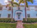 Exterior shot of a charming blue apartment building with well-manicured lawn, palm trees, and walkway to entrance at 5191 Salmon Se Dr # C, St Petersburg, FL 33705