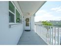 Balcony view with white railing, 'Exit' sign, and door adorned with wreath, inviting entry at 5356 81St N St # 26, St Petersburg, FL 33709