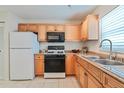 Bright kitchen features a gas range, microwave, and double stainless steel sink at 5356 81St N St # 26, St Petersburg, FL 33709