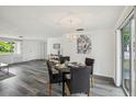 Dining area features a modern chandelier, stylish furniture, and beautiful gray floors at 5620 Perkin Dr, New Port Richey, FL 34652