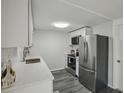 Modern kitchen with stainless steel appliances, white cabinetry, and sleek countertops at 5620 Perkin Dr, New Port Richey, FL 34652
