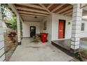 View of covered carport featuring a picnic table, red garbage container and access to the front and back door at 601 N Franklin St, Plant City, FL 33563